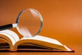 Magnifying glass on opened book Royalty Free Stock Photo