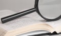 Magnifying glass on opened old book for searching and reading concept Royalty Free Stock Photo