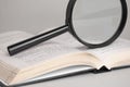 Magnifying glass on opened old book for searching and reading concept Royalty Free Stock Photo