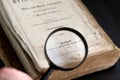Magnifying glass over ancient german book of 1910 on dark background. Russia, 27.12.2020