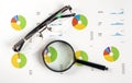 Magnifying Glass Over colorful Graph chart with spectacles eye glasses