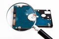 Magnifying glass over a computer hard drive. Hard disk of a laptop. Royalty Free Stock Photo