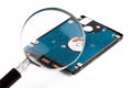 Magnifying glass over a computer hard drive. Hard disk of a laptop. Royalty Free Stock Photo