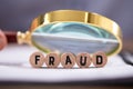 Magnifying Glass Over The Fraud Word Royalty Free Stock Photo