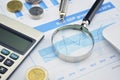 Magnifying glass, pen and calculator on financial chart and grap Royalty Free Stock Photo
