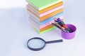 Magnifying glass, pencils and stack of books on white background