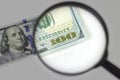 Magnifying glass on a pile of 100 dollar banknotes. Checking suspicious money of magnifying glass Royalty Free Stock Photo