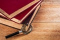 Magnifying glass and pile of old books Royalty Free Stock Photo