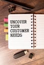 magnifying glass, plant, pen and a white notebook with the text uncover your customer needs