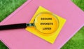 A magnifying glass is positioned over a yellow sticky note displaying the words secure sockets layer, resting on a pink notebook