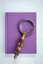 Magnifying glass on purple notebook