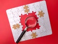 a magnifying glass in a puzzle on a red background
