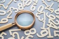A magnifying glass and random wooden numbers Royalty Free Stock Photo