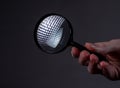 Magnifying glass with reflection in female hands on dark black or gray background Royalty Free Stock Photo
