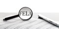 Magnifying glass with text FELA on the background with pen Royalty Free Stock Photo