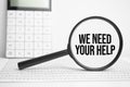 Magnifying glass with text We need your Help on white table with calculator Royalty Free Stock Photo