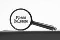 magnifying glass with text press release on notebook Royalty Free Stock Photo