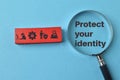 Magnifying glass with text PROTECT YOUR IDENTITY and data protection symbols Royalty Free Stock Photo