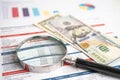 Magnifying glass and US dollar banknotes on spreadsheet and charts graphs paper. Financial development, Banking Account, Royalty Free Stock Photo