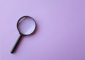 Flat lay and top view magnifying glass on the on a purple background