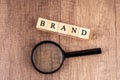 Magnifying glass and wood block with text Brand Royalty Free Stock Photo