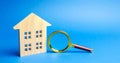 Magnifying glass and wooden house. House searching concept. Home appraisal. Property valuation. Choice of location for the Royalty Free Stock Photo