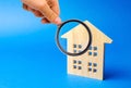 Magnifying glass and wooden house. House searching concept. Home appraisal. Property valuation. Choice of location for the