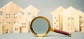 Magnifying glass and wooden houses. House searching concept. Home appraisal. Property valuation. Choice of location for the Royalty Free Stock Photo