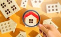 Magnifying glass and wooden houses. House searching concept. Home appraisal. Property valuation. Choice of location for the Royalty Free Stock Photo