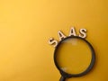 Magnifying glass and wooden word with text SAAS Royalty Free Stock Photo