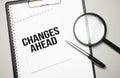 Magnifying glass with the word Changes Ahead on white background Royalty Free Stock Photo