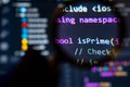 Magnifying glass zooming into colorful C programming code on screen, emphasizing a recursive factorial function in a development Royalty Free Stock Photo