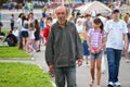 Magnitogorsk, Russia, - August, 22, 2014. Elderly homeless man walks among people around the town square. Summer in the city