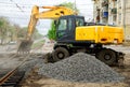 Magnitogorsk, Russia, - May, 17, 2019. The yellow excavator falls asleep rubble repaired tram rails. Crossroads of Marx and