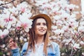 Magnolia. girl or cute woman near blossoming, magnolia flowers tree in spring park on spring sunny day Royalty Free Stock Photo