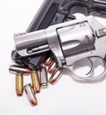 A 357 magnum revolver on top of a 40 caliber pistol with eight 40 caliber hollow point bullets Royalty Free Stock Photo