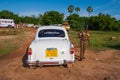 Indian policeman next to a car policing an open air celebration