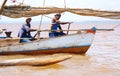 Malagasy fishermen row on a small sailboat