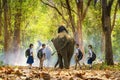 Mahout and student little asian in uniform are raising elephants on walkway in forest. Student little asian girl and boy singsong Royalty Free Stock Photo