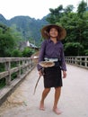 A woman with farm implements heads to work in a rice field in the Mai Chau valley, Vietnam