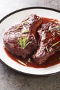 Maiale Ubriaco Drunken Pork chops in red wine sauce with herbs closeup on the plate. Vertical Royalty Free Stock Photo