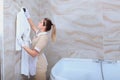 The maid in the bathroom hangs a white Terry-cloth robe on a hanger. The concept of service to our guests. Copy of the Royalty Free Stock Photo