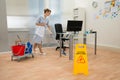 Maid cleaning floor in office