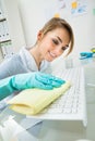 Maid cleaning keyboard at desk Royalty Free Stock Photo