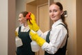 Maid cleans mirror in hotel bathroom spraying detergent Royalty Free Stock Photo