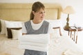 Maid holding towels in hotel room smiling Royalty Free Stock Photo