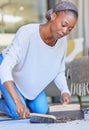 Maid, housekeeping and black woman cleaning and sweeping floor of a living room in a home or house for hygiene Royalty Free Stock Photo