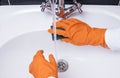 Maid or housewife cleaning wash basin.  WomanÃ¢â¬â¢s gloved hands washing white washbasin. Close-up of hand with sponge. Cleaning Royalty Free Stock Photo