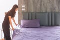 Maid housewife woman Preparing Bed pull tight neat bed sheet. Lady working chores housekeeping cleaning bedroom at home or hotel Royalty Free Stock Photo