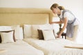 Maid making bed in hotel room Royalty Free Stock Photo